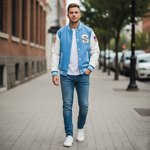 Man wearing a blue and white varsity jacket on a city street.