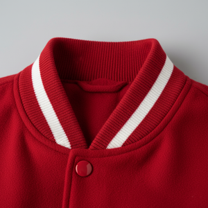 Close-up of a red cardigan with white trim on a gray background