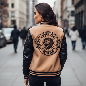 Woman wearing a tan and black varsity jacket with a lion graphic and text on a city street.