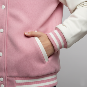 Close-up of a pink varsity jacket with white accents on a neutral background
