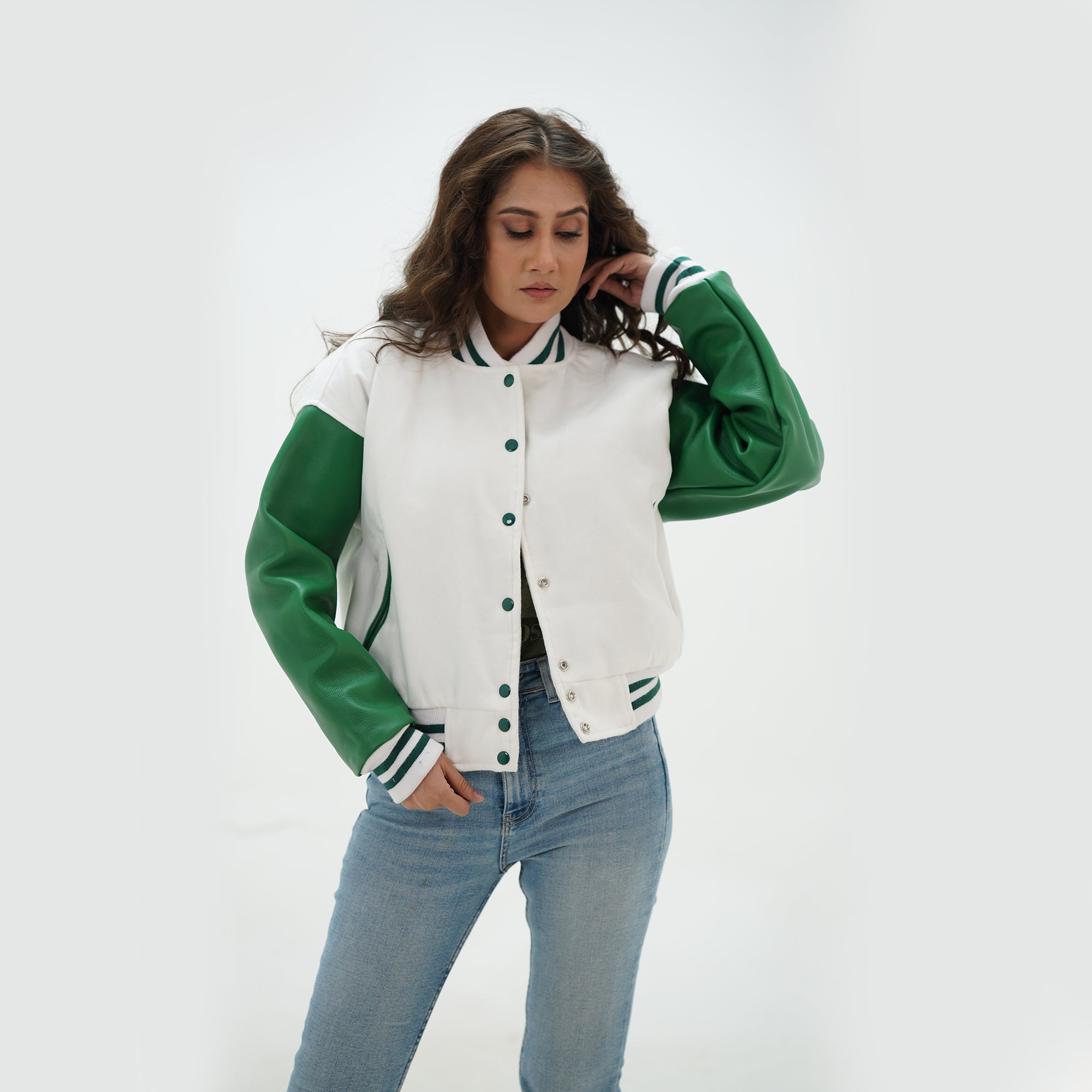 Close-up detail of white and green varsity jacket featuring white wool and green leather sleeve junction with ribbed collar trim