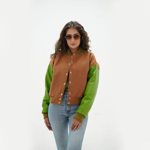 Side angle of women's brown and parrot green letterman jacket showing parrot green leather sleeve detail, ribbed cuffs, and tailored feminine silhouette