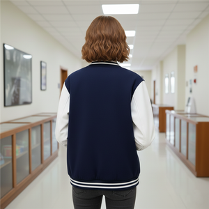 Person wearing a navy blue letterman jacket in a school hallway