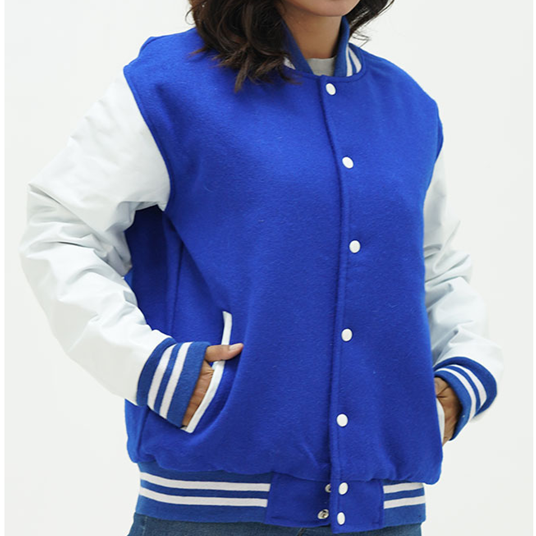 A woman wearing a royal blue and white letterman jacket with leather arms and a wool body. The jacket features a classic ribbed collar, white leather sleeves with blue stripes, and two leather-edged side pockets.