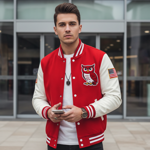 Man wearing a red and white varsity jacket with an owl design, standing outdoors.