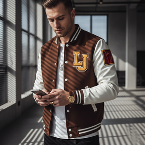 Man wearing a brown and white varsity jacket with 'LJ' lettering, using a phone indoors.