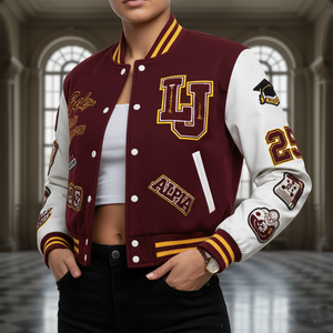 Person wearing a maroon and white varsity jacket with various patches in an indoor setting.