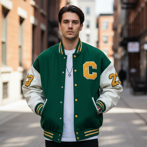 Man wearing a green and white varsity jacket with yellow accents on a city street.