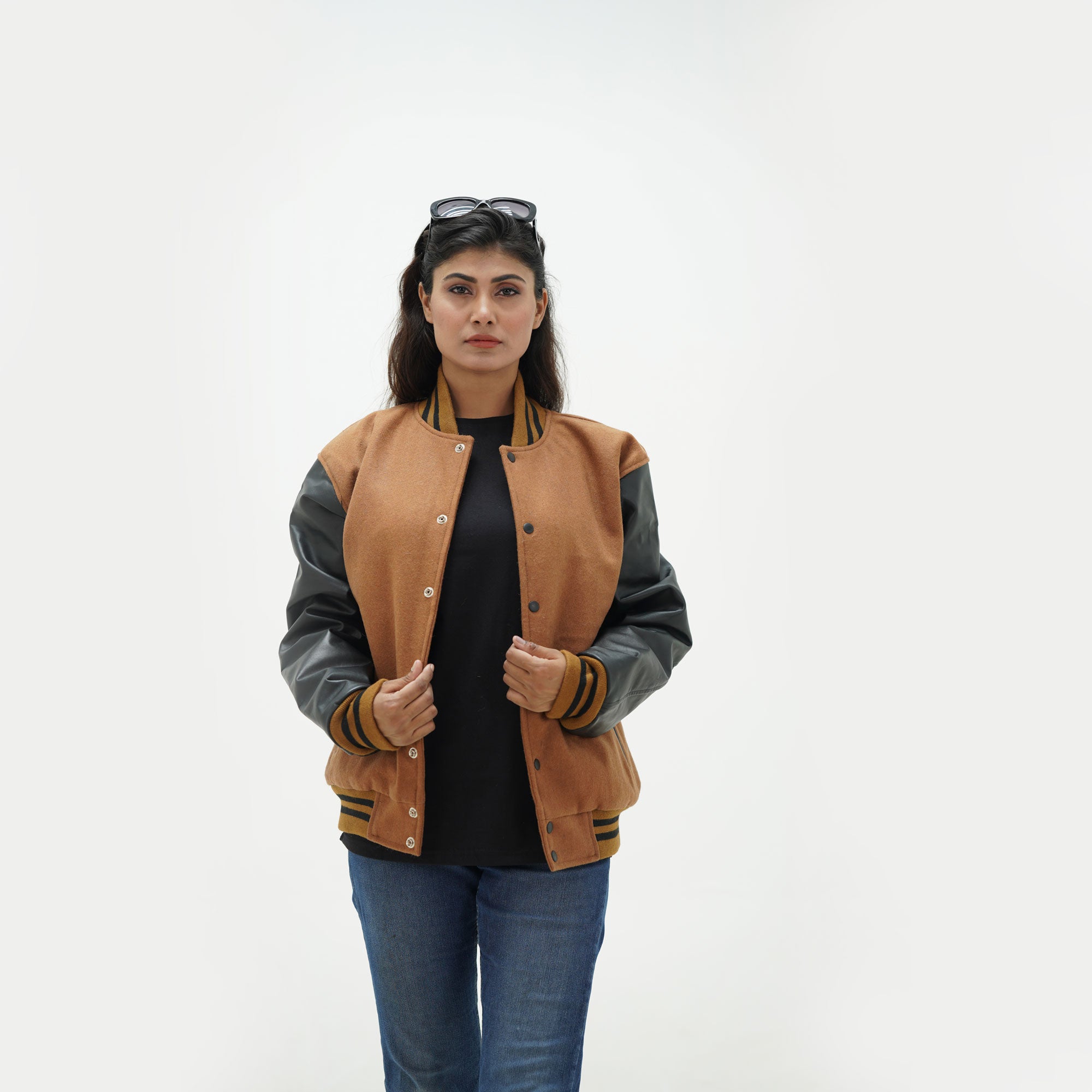 Close-up detail of brown wool and black leather sleeve junction on women's all American varsity jacket with blue ribbed collar