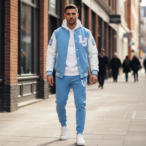 Man wearing a blue and white varsity jacket with 'LJ' logo on a city street.