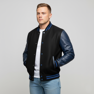 Man wearing a black varsity jacket with blue sleeves on a gray background