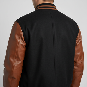 Black jacket with brown leather sleeves on a plain background