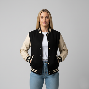 Woman wearing a black and cream varsity jacket on a gray background