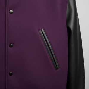 Close-up of a purple jacket with black leather sleeves and pocket on a gray background