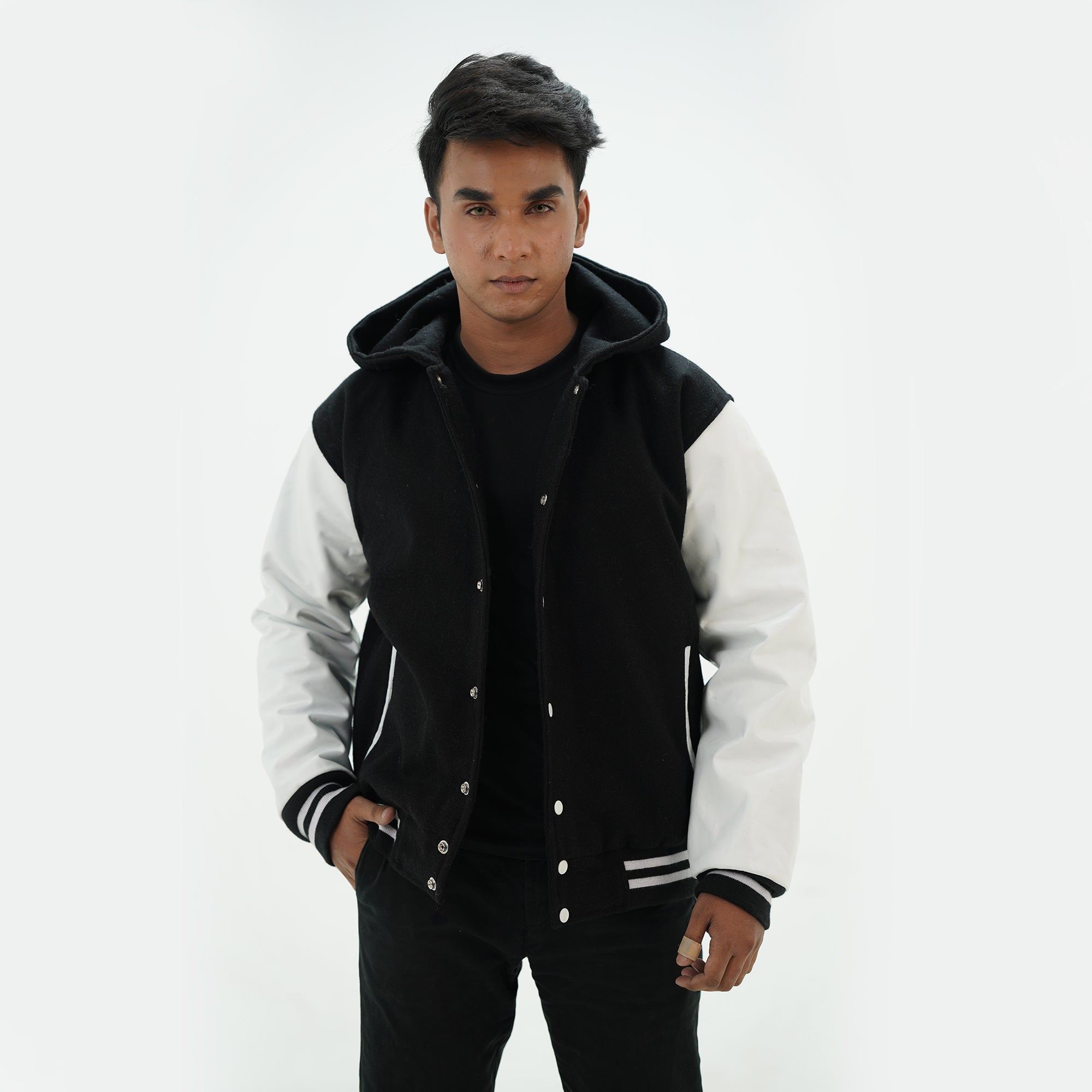 Front view of black and white hooded letterman jacket featuring wool body white leather sleeves and snap-button fastening