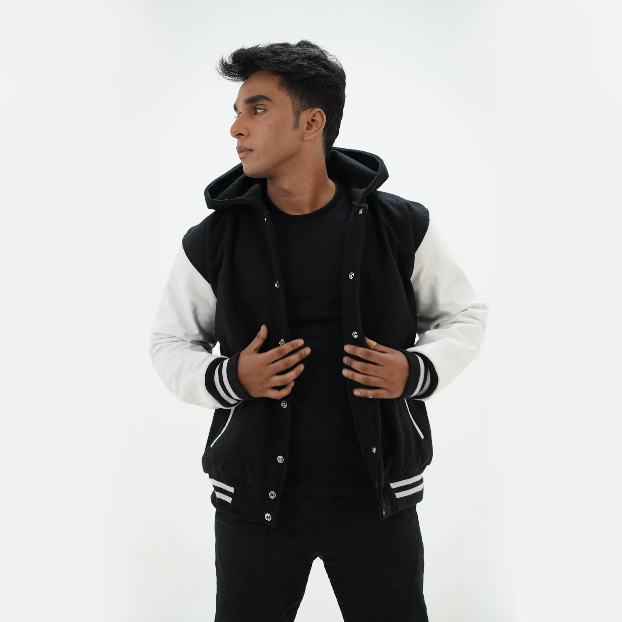 Side angle of black and white hooded letterman jacket highlighting genuine cowhide white leather sleeves and quilted lining