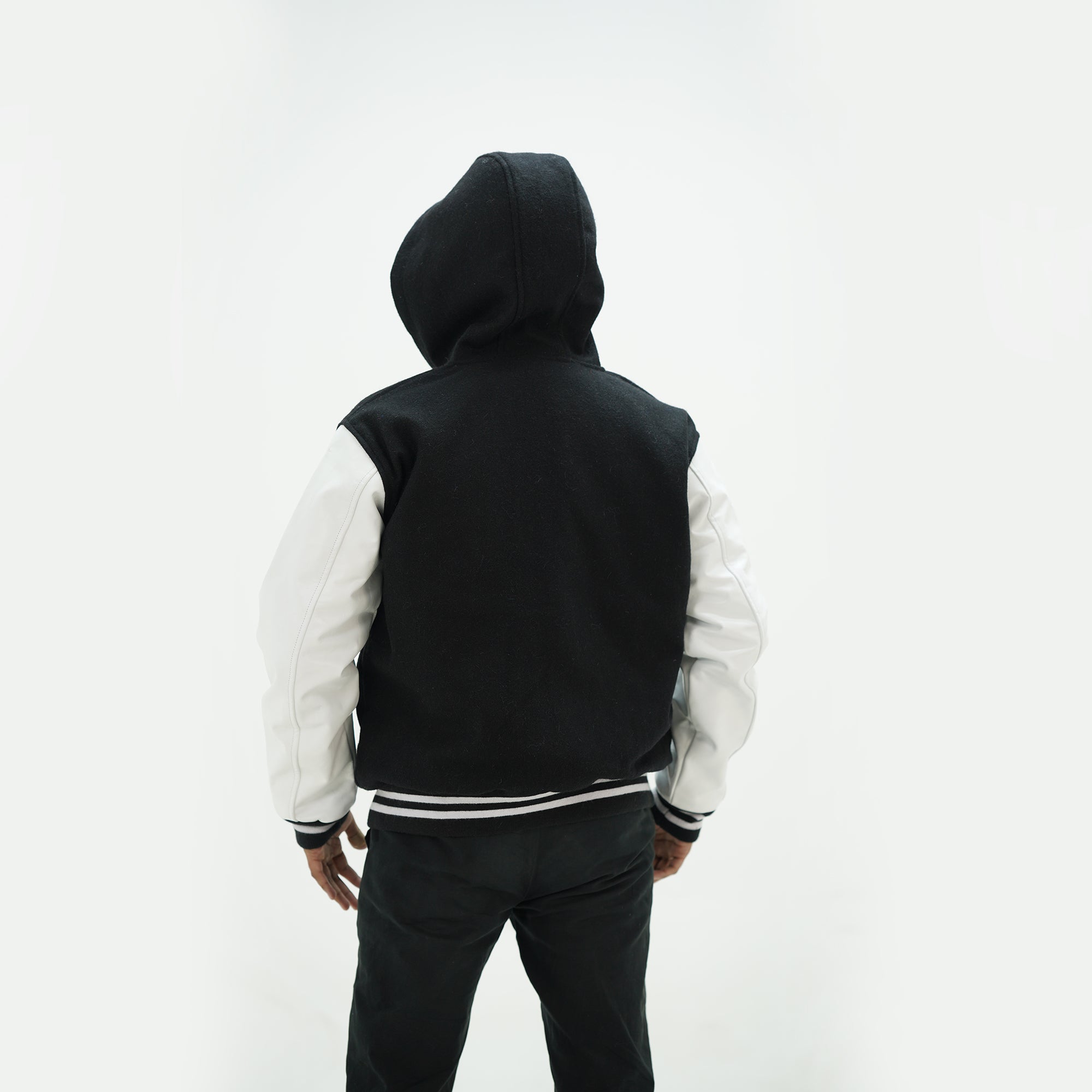 Back view of black and white letterman jacket with hoodie showing premium Melton wool construction and timeless design