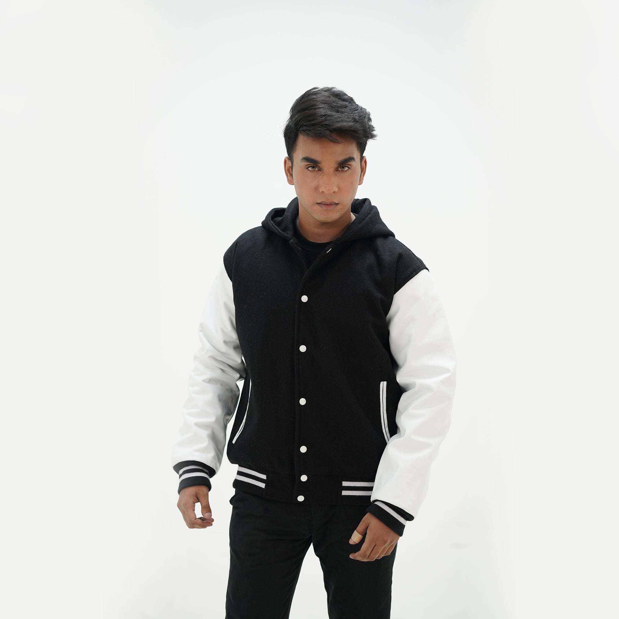 Close-up detail of black and white letterman jacket with hoodie featuring custom embroidery options and cotton rib trim