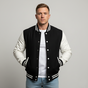 Man wearing a black and white varsity jacket on a gray background