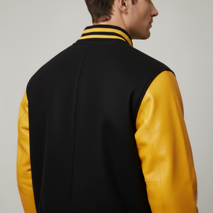 Person wearing a black and yellow varsity jacket on a plain background