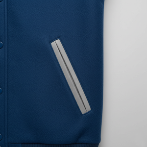 Close-up of a blue jacket with a gray stripe on a light gray background