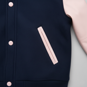 Navy blue varsity jacket with pink buttons and pocket on a light gray background