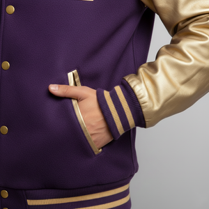 Purple and gold varsity jacket with a hand in the pocket against a gray background