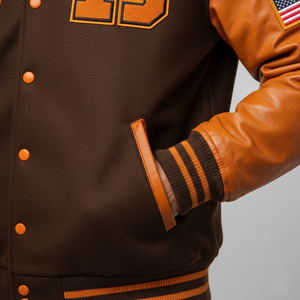 Brown varsity jacket with orange accents on a gray background 