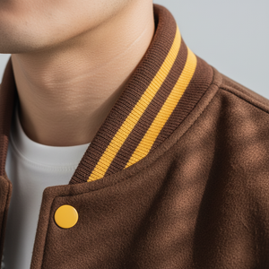 Brown jacket with yellow stripes and button on a neutral background
