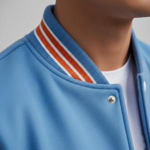 Close-up of a blue jacket with orange and white striped collar against a gray background