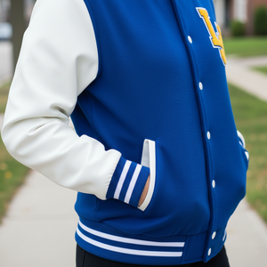 Blue letterman jacket with white sleeves and a logo, worn outdoors.