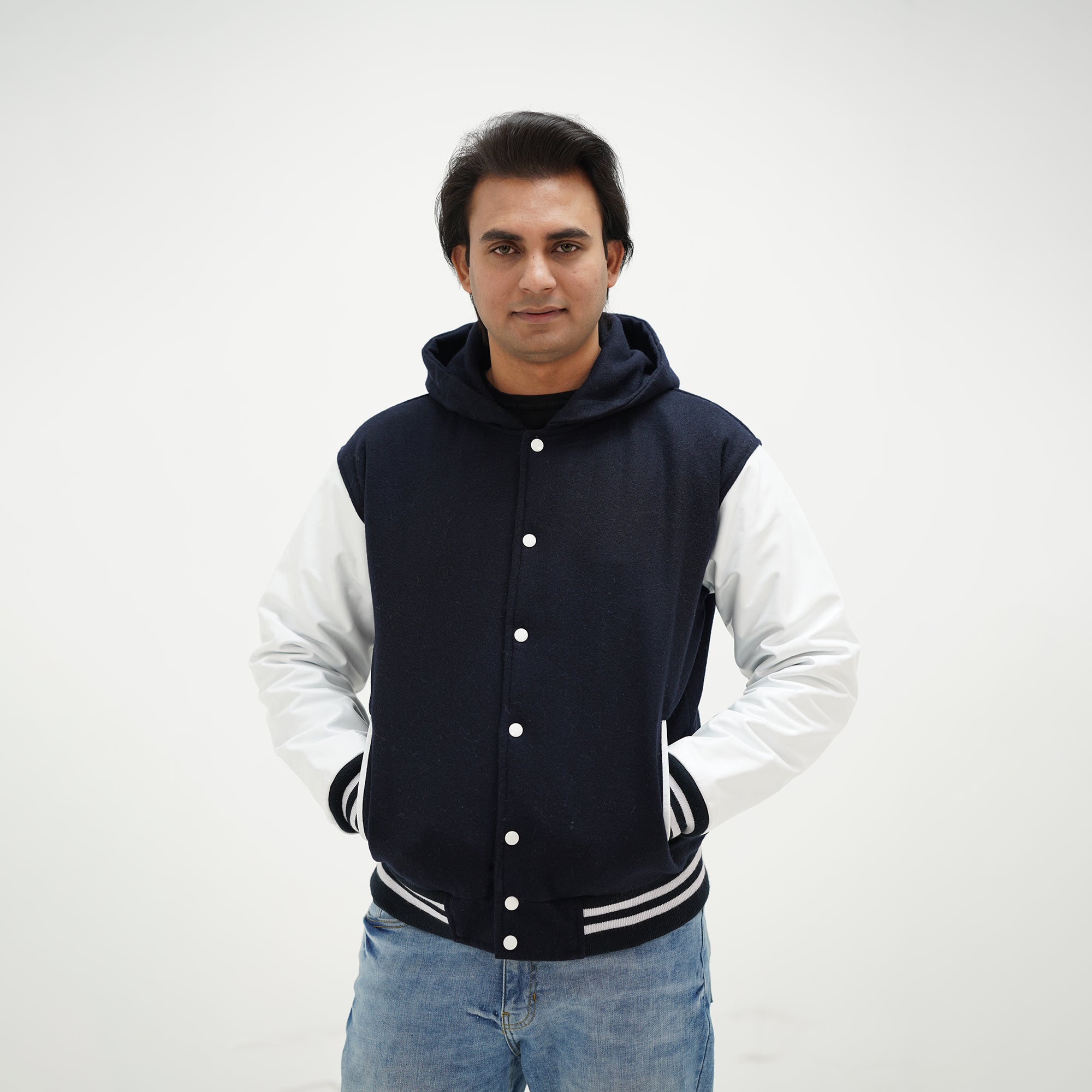 Detailed view of dark blue and white hooded varsity jacket making classic statement with wool body and leather sleeves