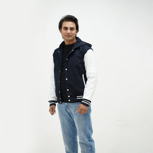 Side angle of dark blue and white varsity jacket with hood highlighting genuine leather sleeves and wool body design