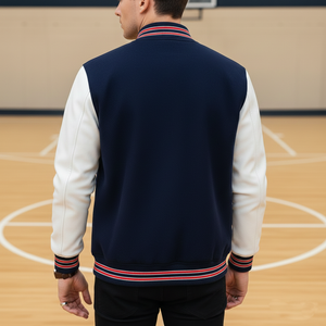 Person wearing a navy and white varsity jacket on a basketball court