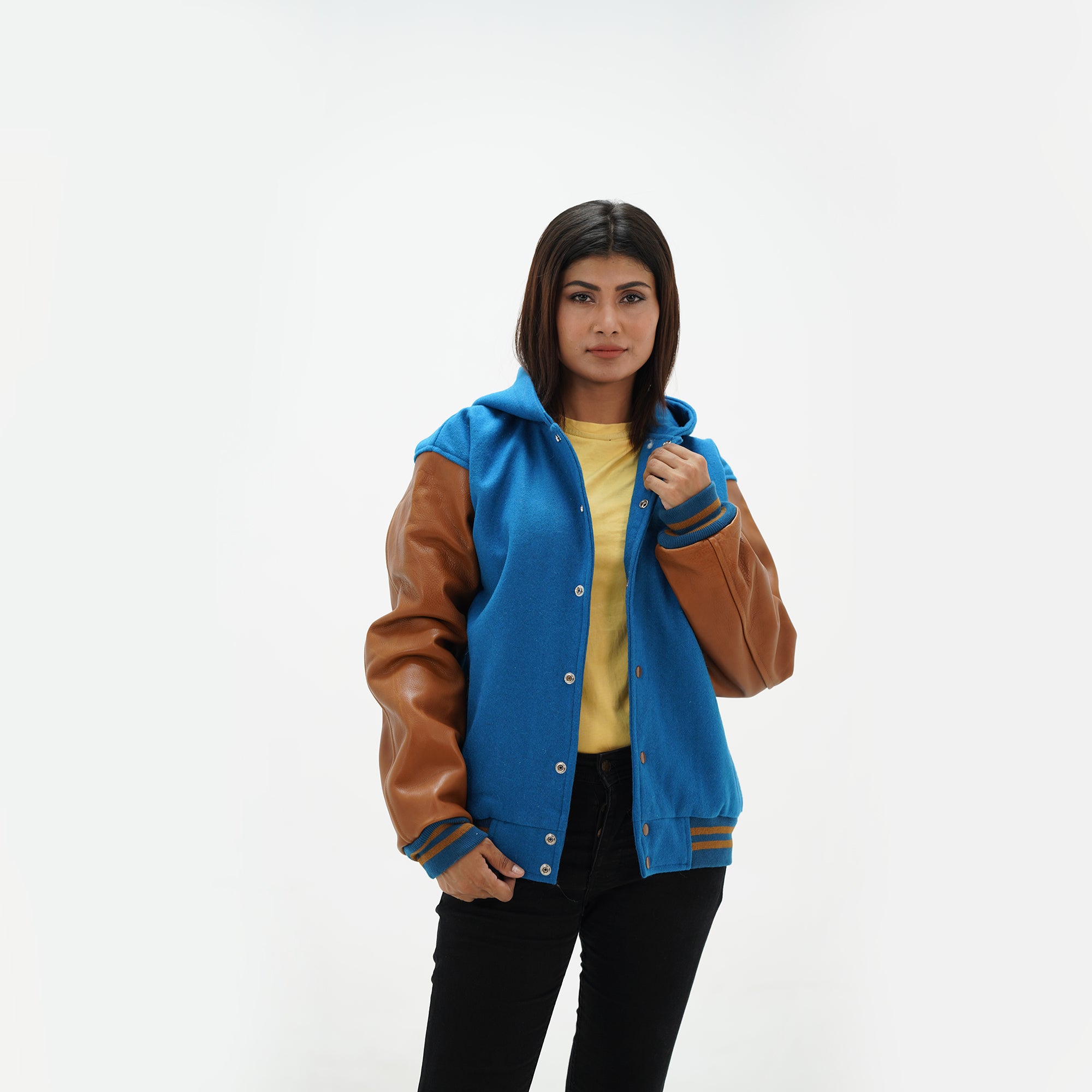 Side angle of girls hooded varsity jacket featuring leather raglan sleeves and striped ribbed cuffs with wool body
