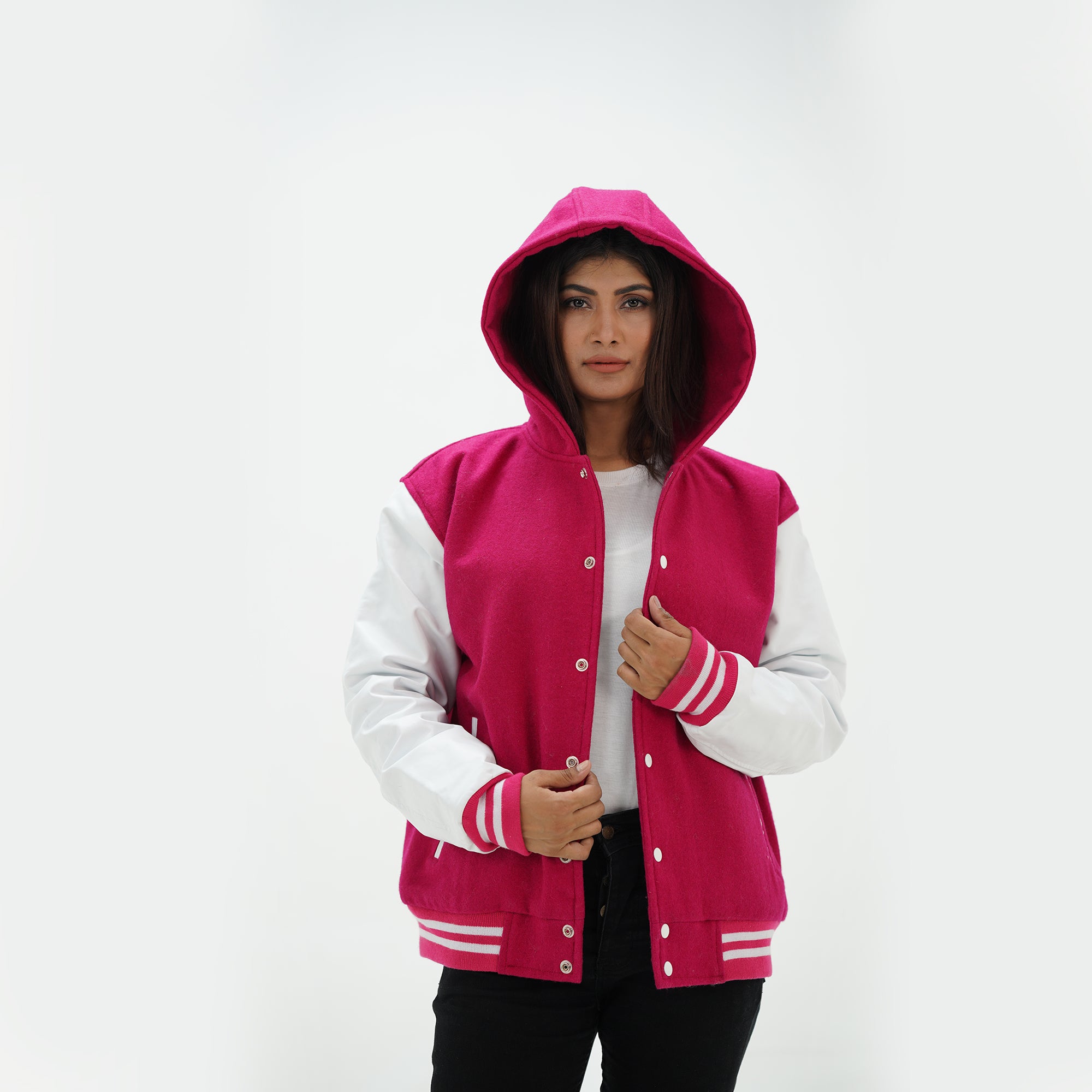 Three-quarter angle of girls pink hooded varsity jacket with white leather sleeves showing wool body construction