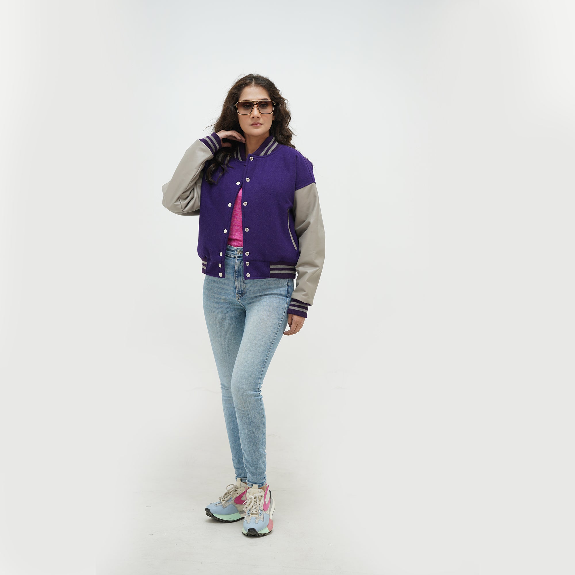 Three-quarter view of girls purple crop letterman jacket highlighting snap button closure, cropped hem, and purple-gray color contrast