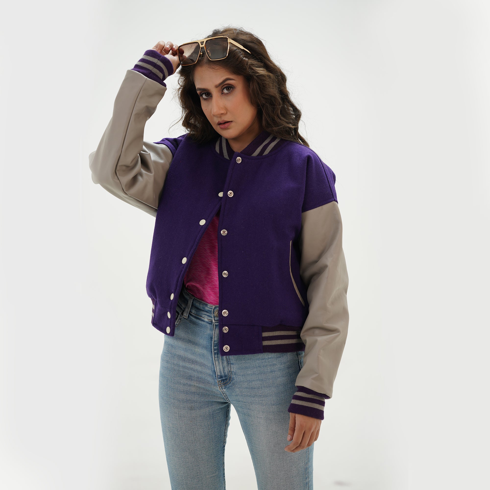 Alternate angle of girls purple and gray crop letterman jacket displaying cropped length, side pockets, and trendy varsity styling