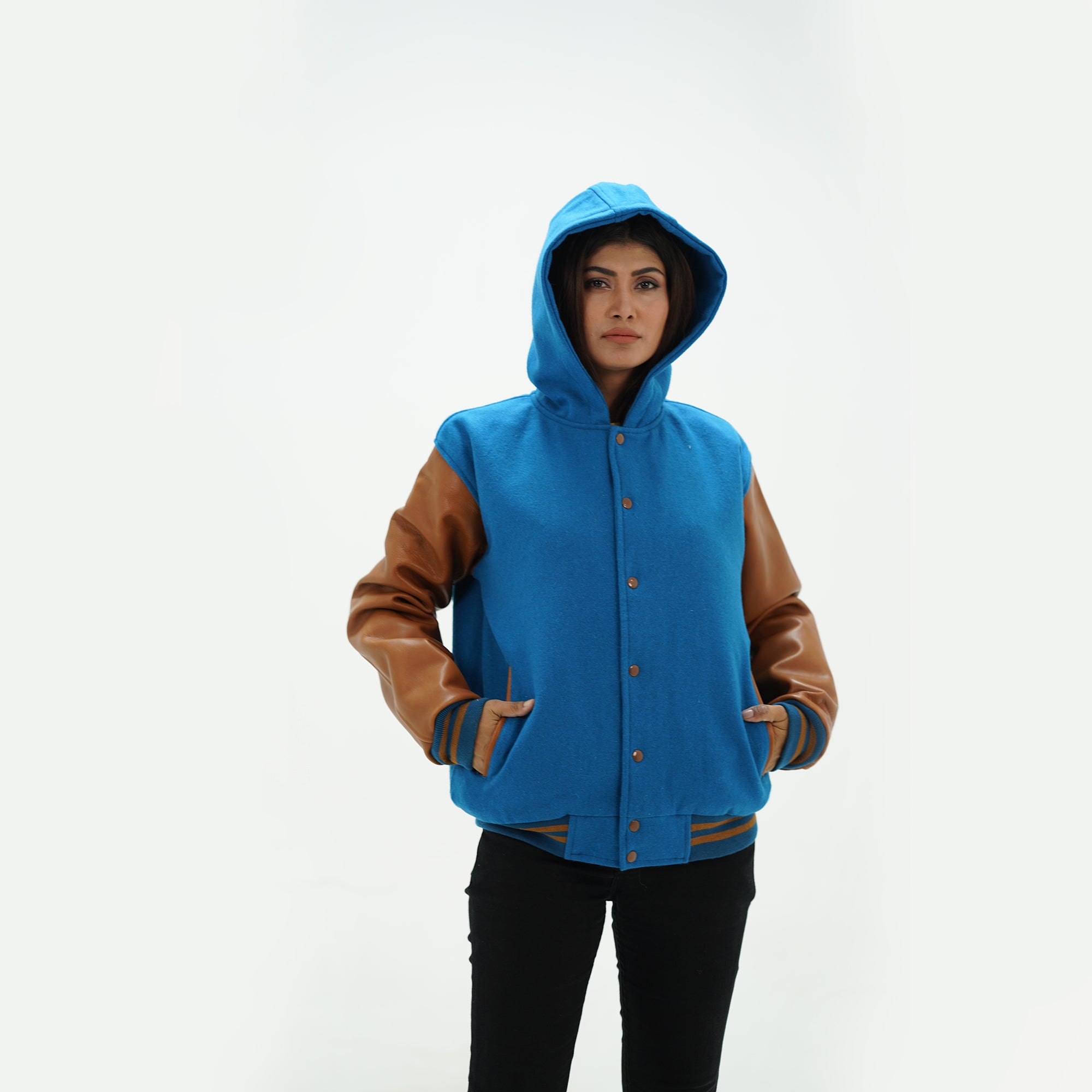 Three-quarter view of girls varsity jacket with integrated hood and leather sleeves showing premium wool construction