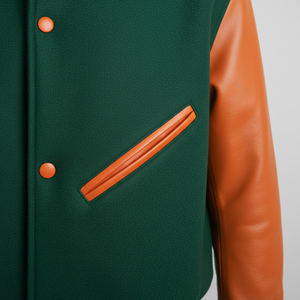 Green jacket with orange leather sleeves and buttons on a light gray background
