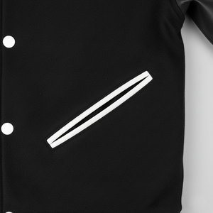 Black letterman jacket with white emblem on a gray background
