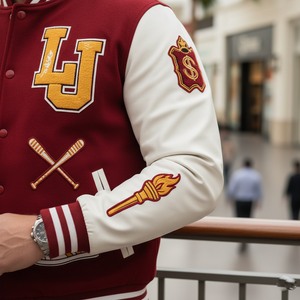Close-up of a maroon and white varsity jacket with logos and symbols, worn indoors.