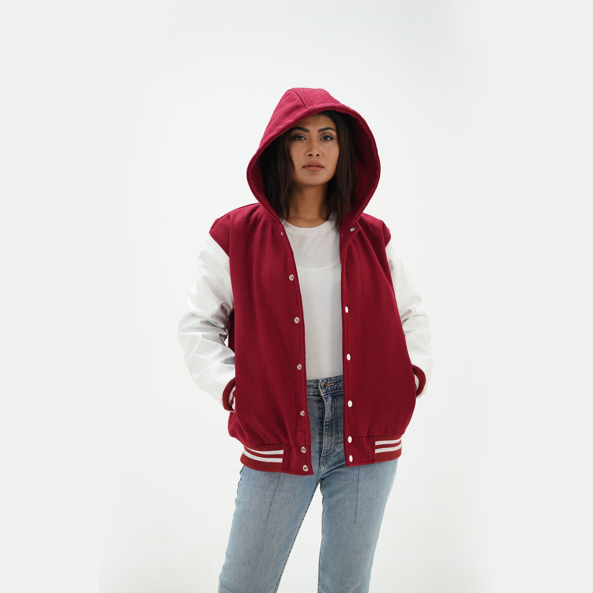 Close-up detail of magenta varsity hoodie jacket featuring magenta wool and white leather construction with attached hood and ribbed collar trim