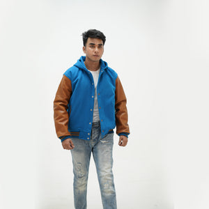 Close-up of men's sky blue varsity jacket over hoodie leather-edged side pockets and premium construction details