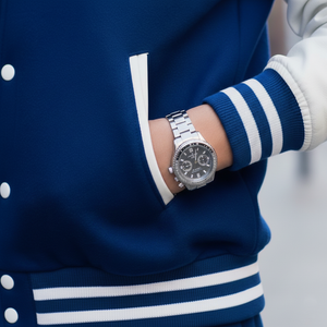 Person wearing a silver watch on a blurred background