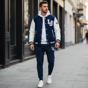 Man wearing a navy and white varsity jacket with 'LJ' logo on a city street.