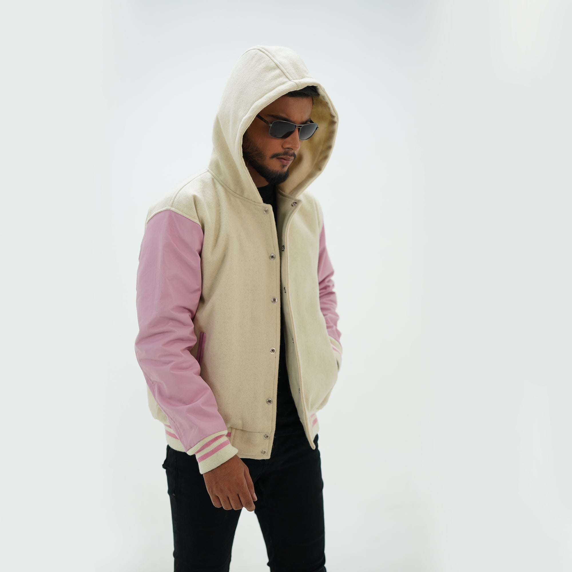 Side angle of off white and pink varsity jacket hoodie highlighting genuine cowhide leather arms and premium wool body