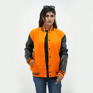 Close-up detail of vibrant orange wool and black leather sleeve junction on women's varsity jacket with ribbed collar trim