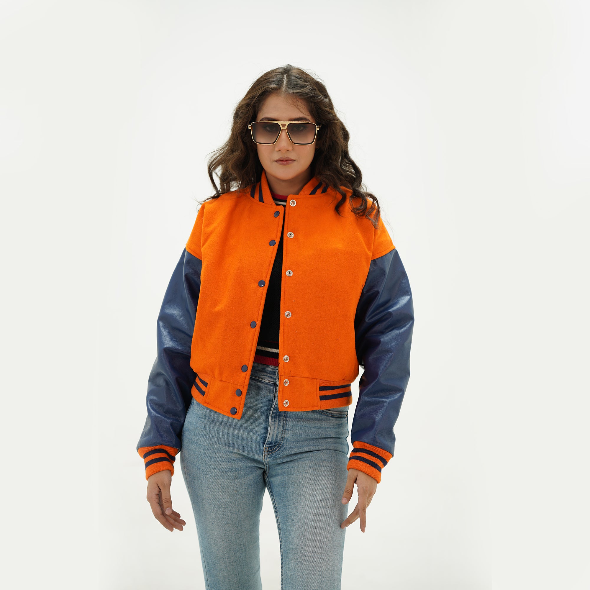 Close-up detail of orange and java plum crop jacket featuring orange wool and java plum leather sleeve junction with ribbed collar trim