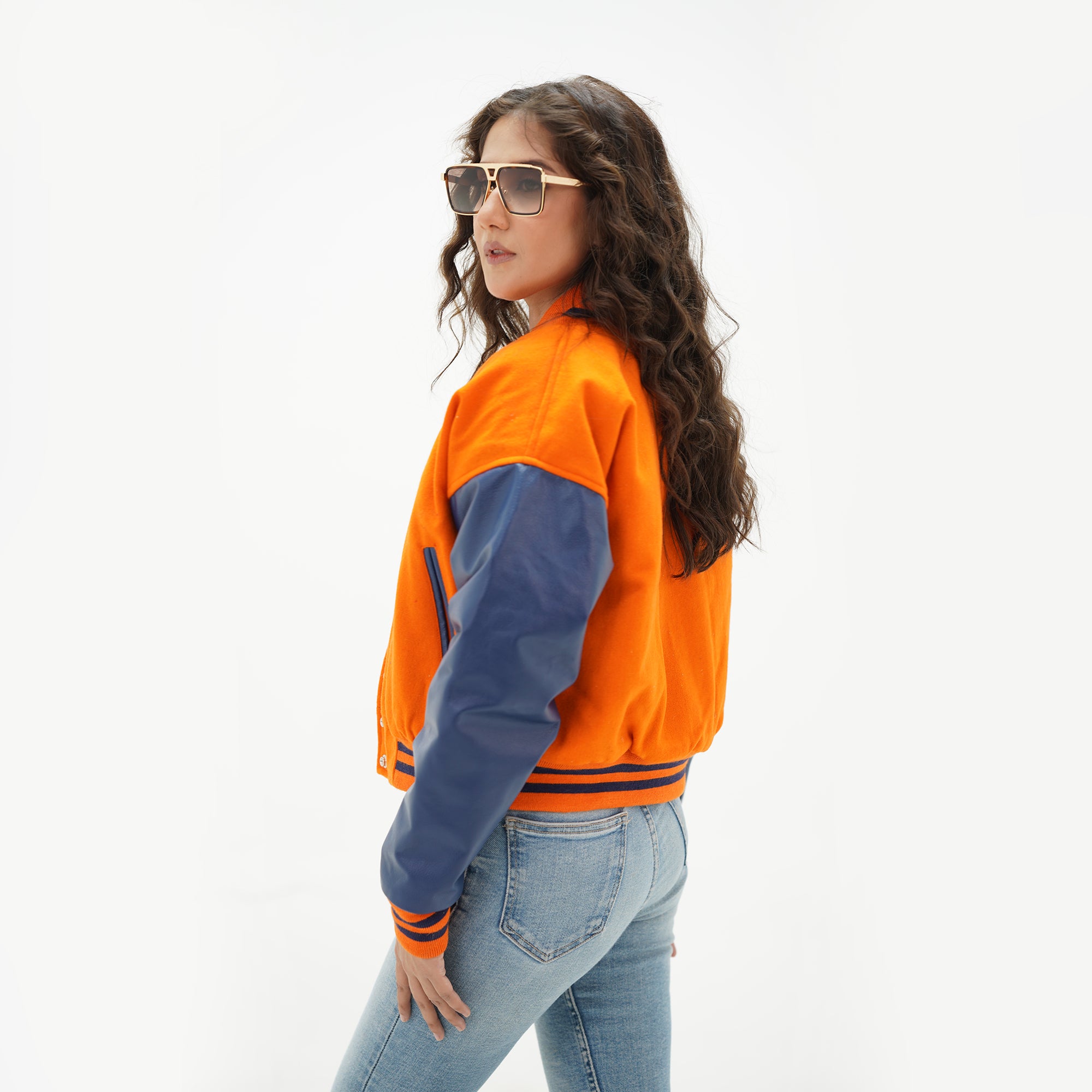 Back view of orange and java plum crop varsity jacket displaying orange Melton wool body, java plum genuine leather sleeves, and cropped ribbed hem